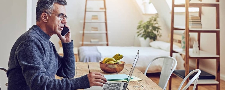 Man sits at his laptop and talks on the phone as he takes steps to make sure his identity wasn’t stolen.