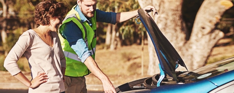 A woman gets help with her broken down car, which might require her to dip into her emergency funds to pay for repairs.