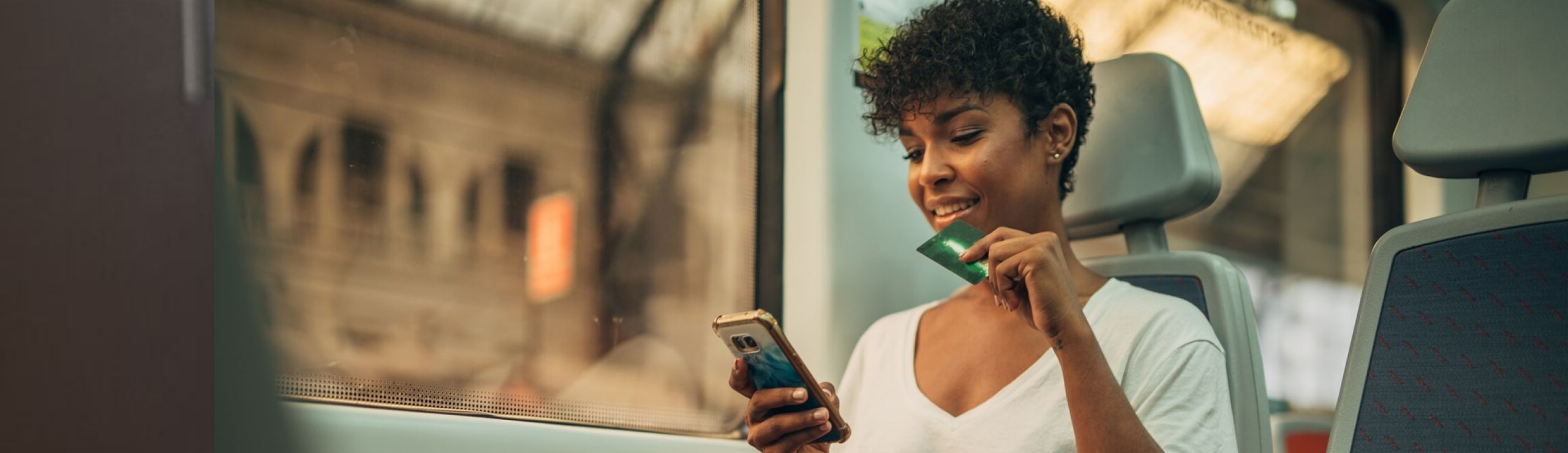 woman holding card and looking at phone