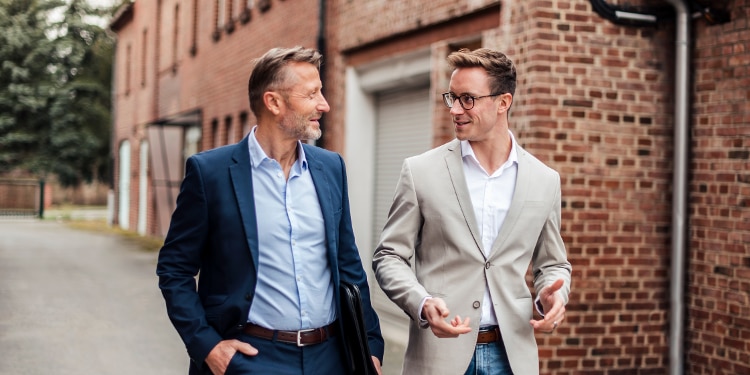 Business-casual dressed men walking in conversation