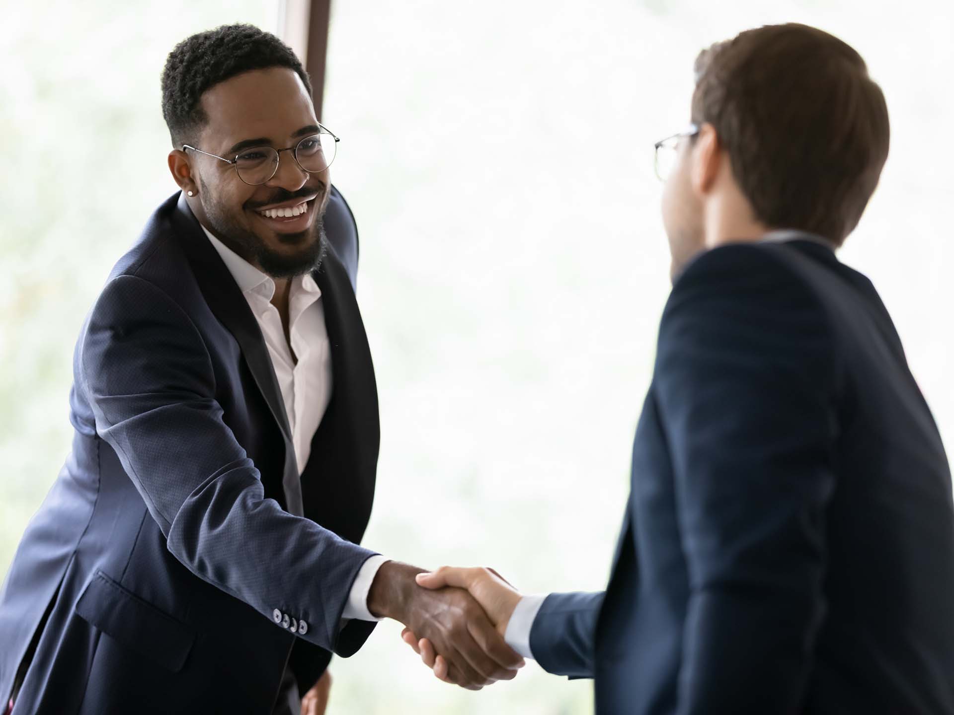 two men in shaking hands in a business setting