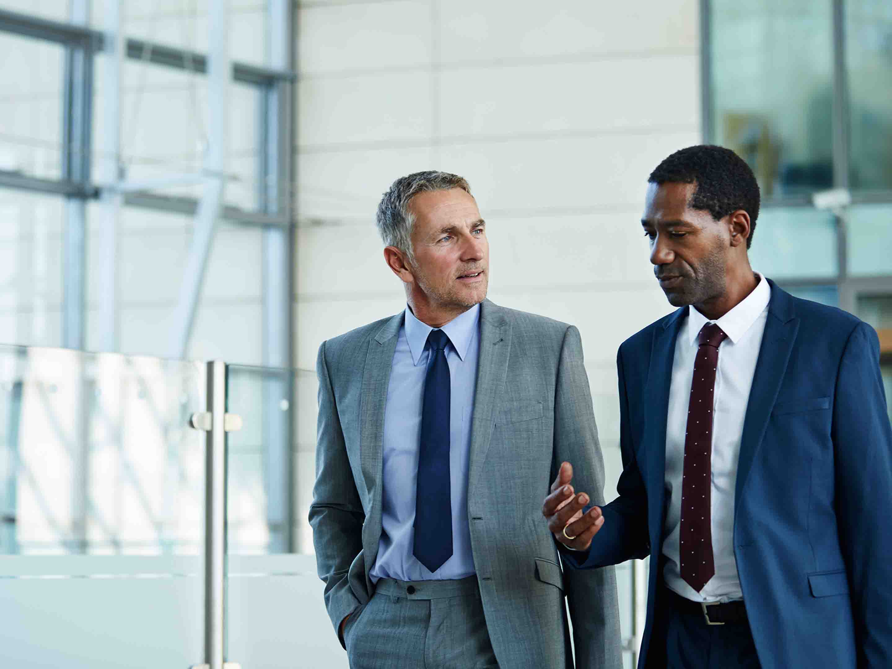 two men in suits having a conversation in a business setting
