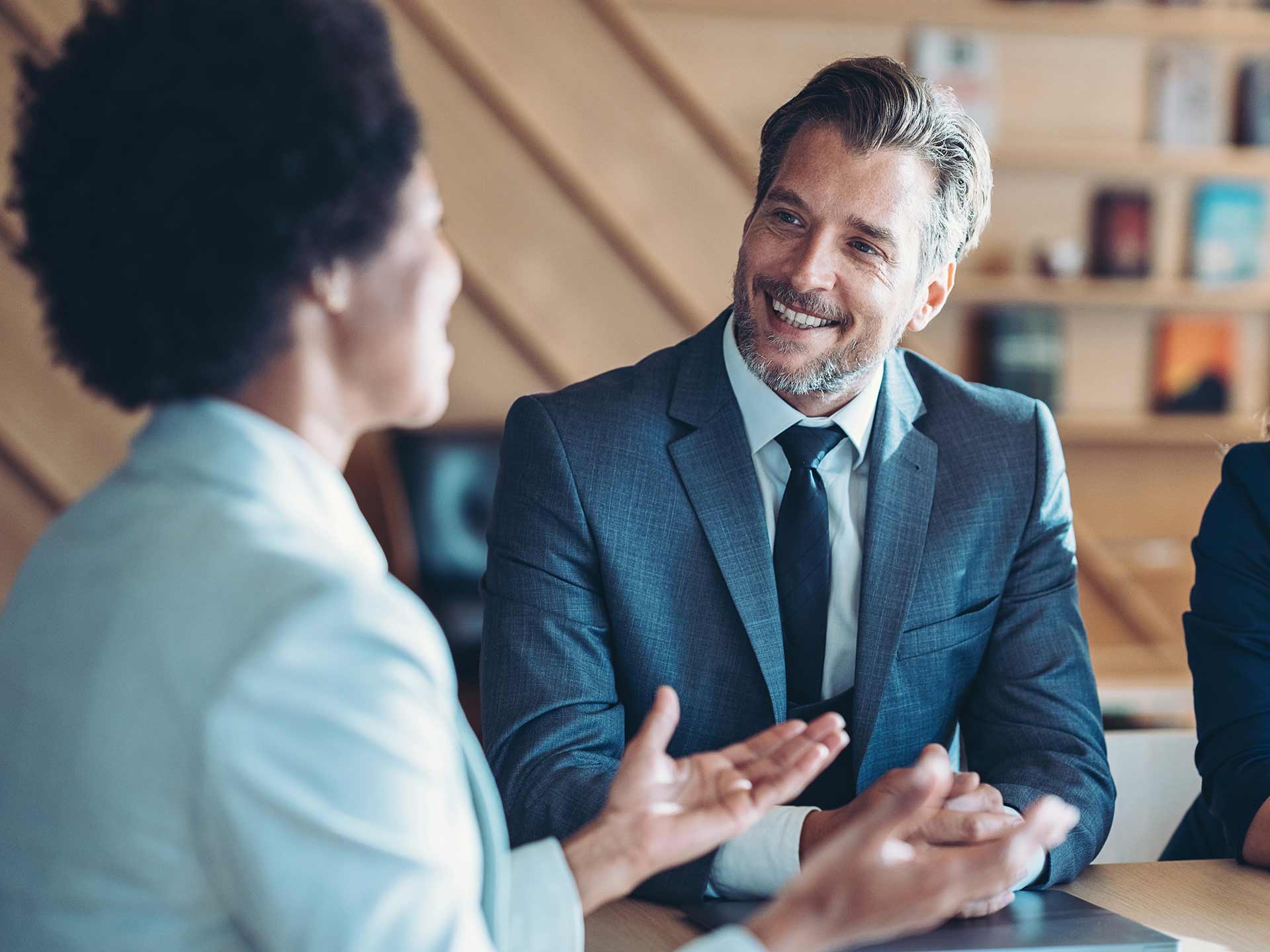 man in grey suit having a meeting with a women in a suit
