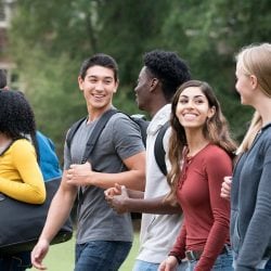 Group of diverse students walk and talk together.