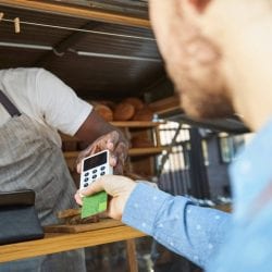 Customer inserts their credit card into a card reader at a bakery food cart