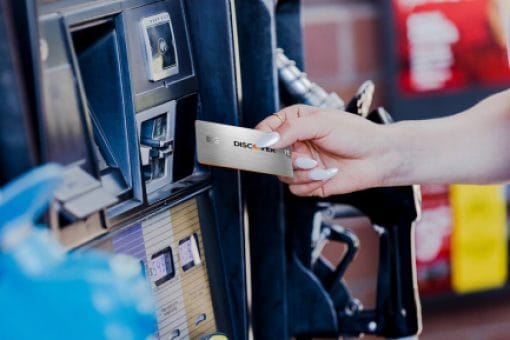 A woman uses her Discover it® Chrome card to pay for fuel at the pump.