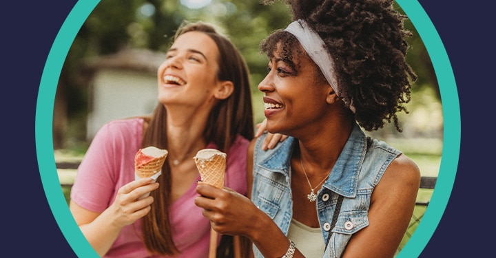 Happy friends eating ice cream and looking at the sky