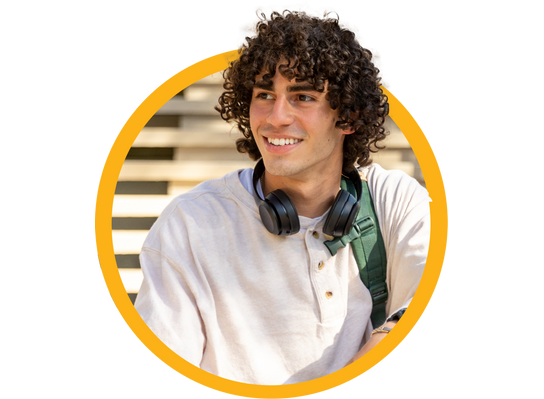 Young man with curly hair, wearing headphones and a white shirt, smiling and looking to the side