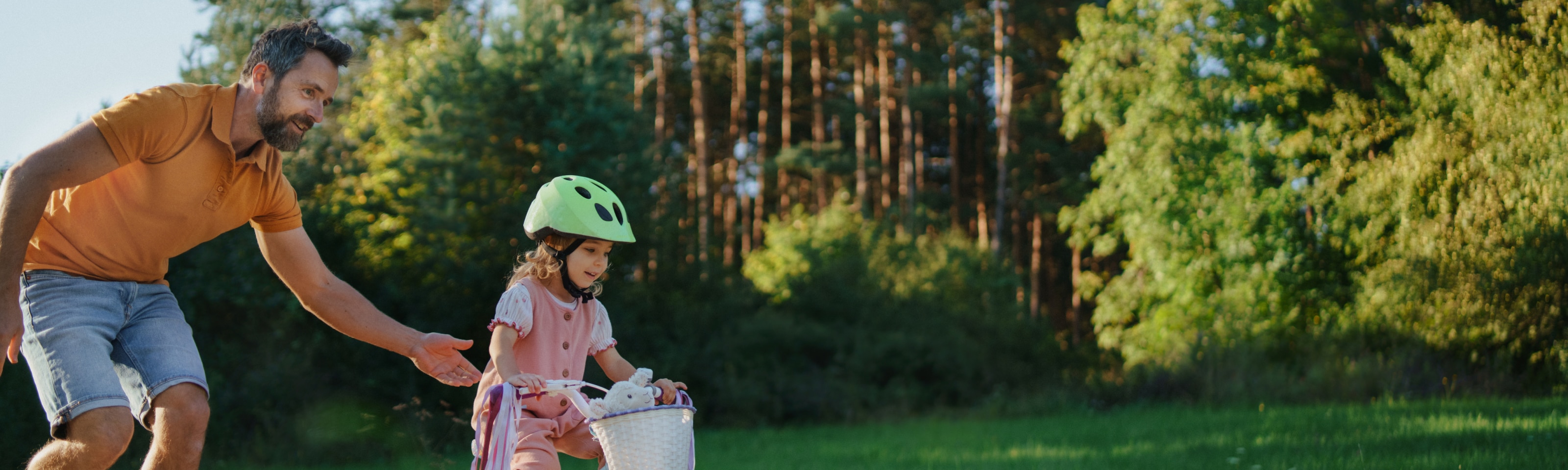 Father teaching child to ride a bike