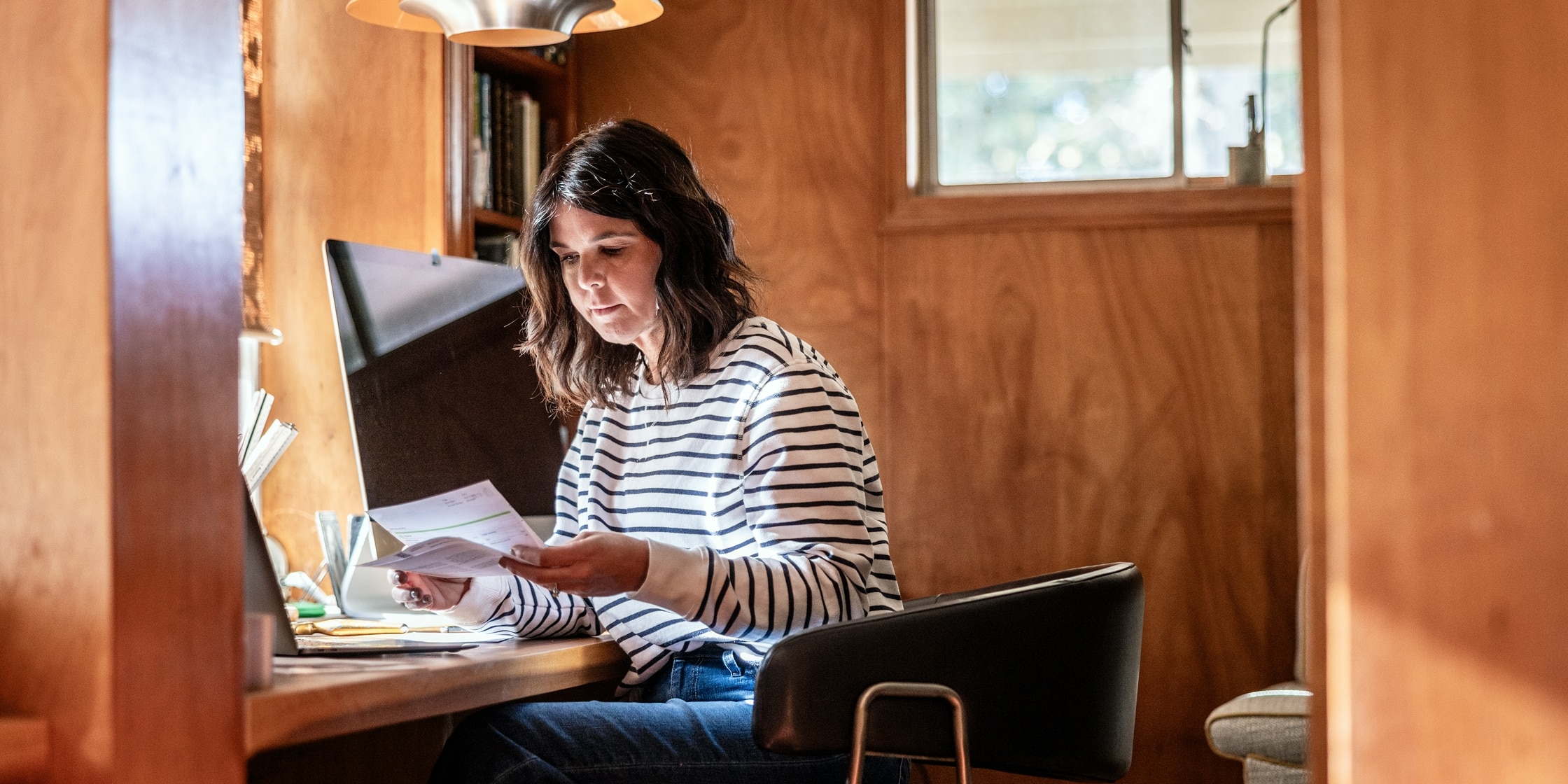 A woman reviews paperwork in her office.