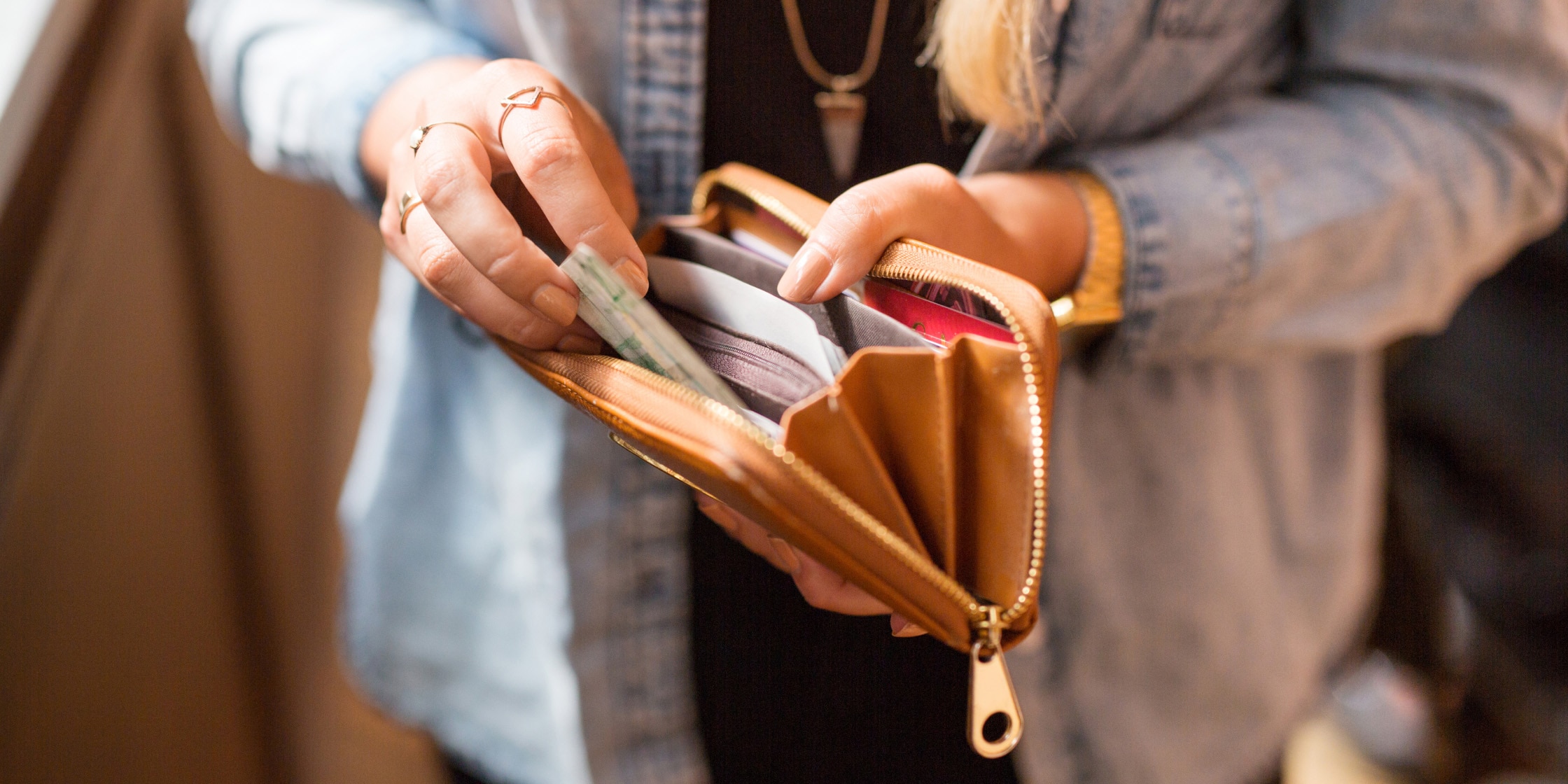 A woman leafs through her wallet.