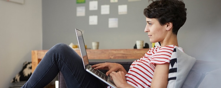 A woman on her laptop considers whether a balance transfer will hurt her credit.