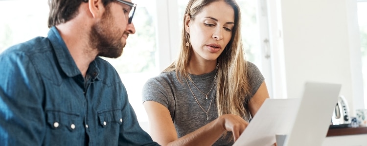 Two people are sitting down and looking at a credit card consolidation plan together.