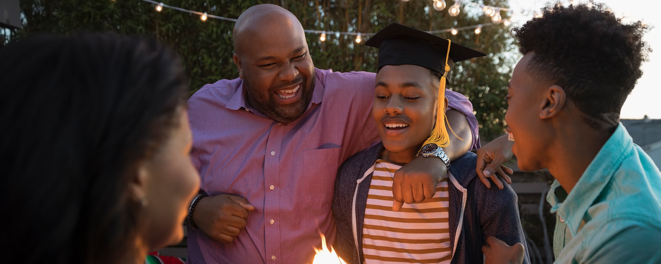Kid with his family celebrating his graduation.