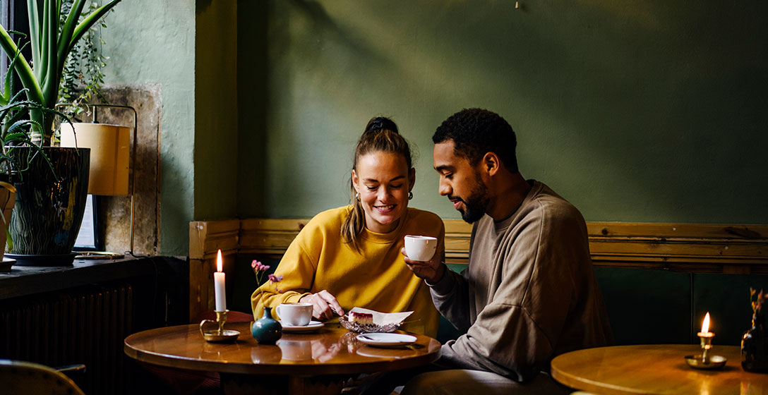 Couple having coffee and cake in coffee shop.