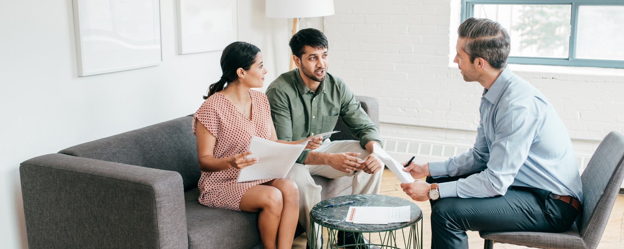 Two people discuss taxes with an adviser.