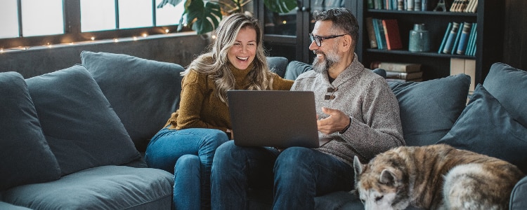 A couple looks at information about mortgage points while sitting and looking at a laptop.