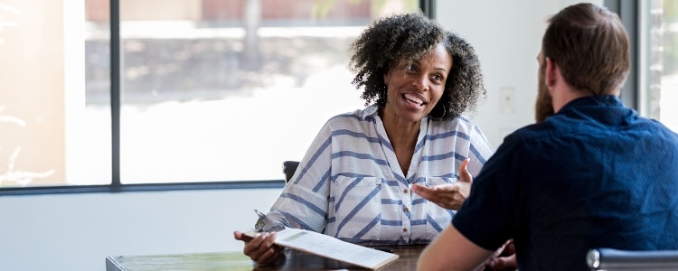 Two people sitting at a table discussing beneficiaries.