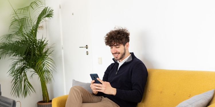 A smiling person checking their Equifax credit report on their smartphone.