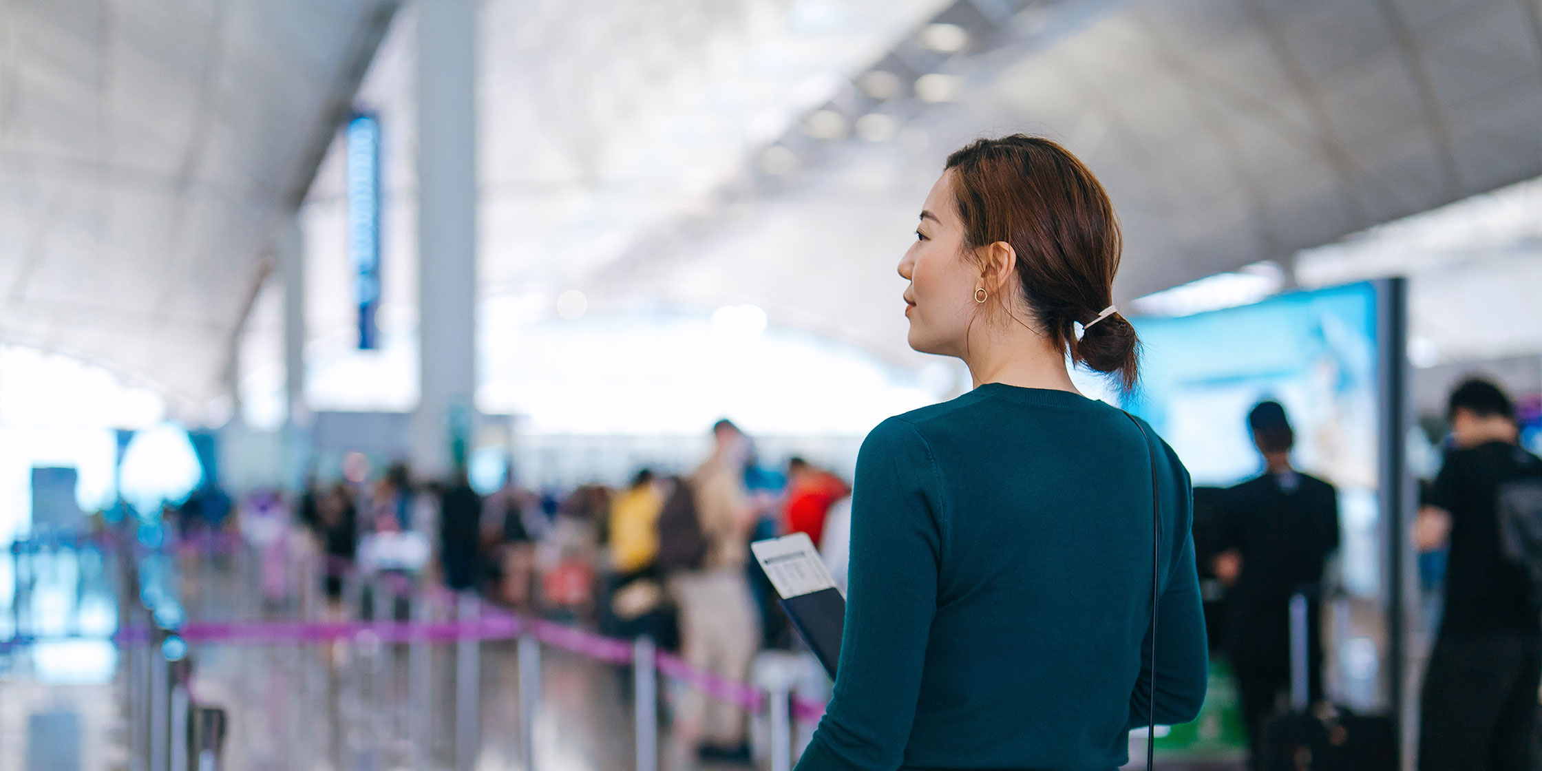 A person entering the airport looks for their designated security line.