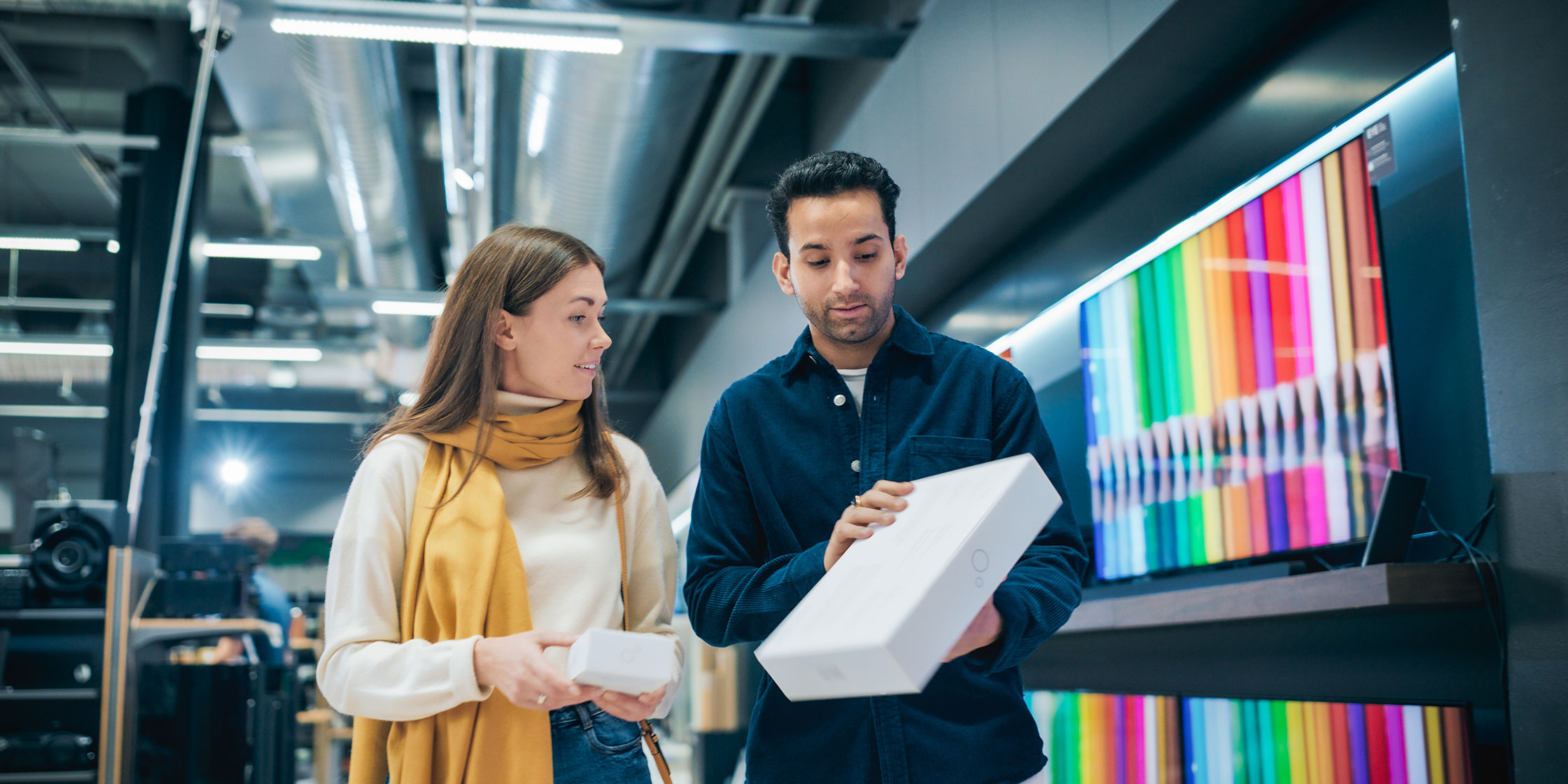 Two people shopping at an electronics store.
