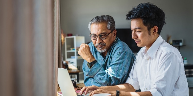 Two people look at a computer for information about co-signing a loan.