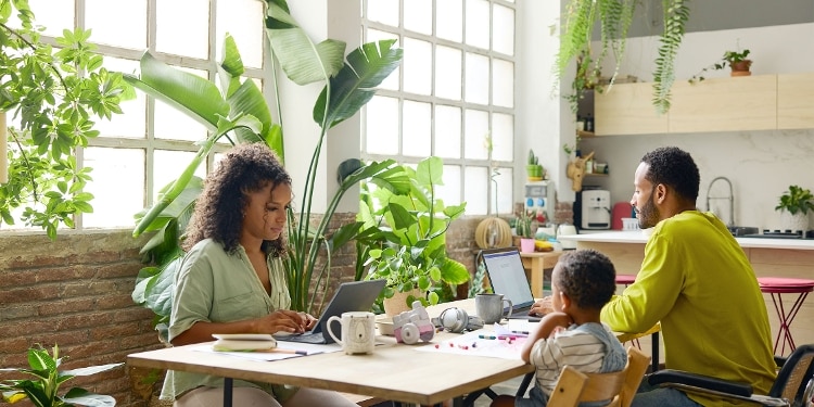 A family sits at a kitchen table reading about how long hard inquiries stay on credit reports.