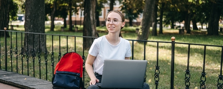 A young person researching the college application process on her laptop.