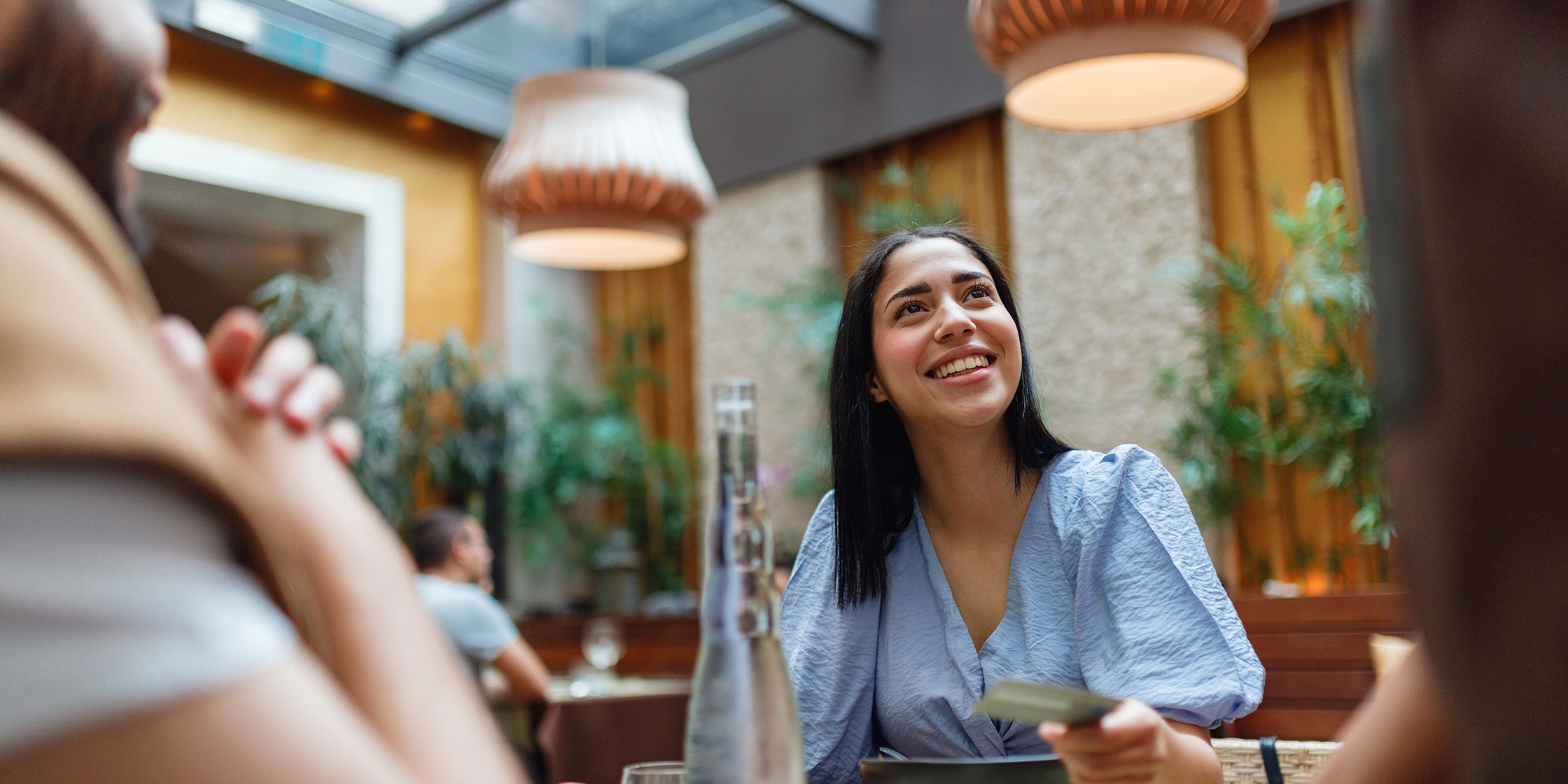 Friends out to eat pay for their bill with a credit card.