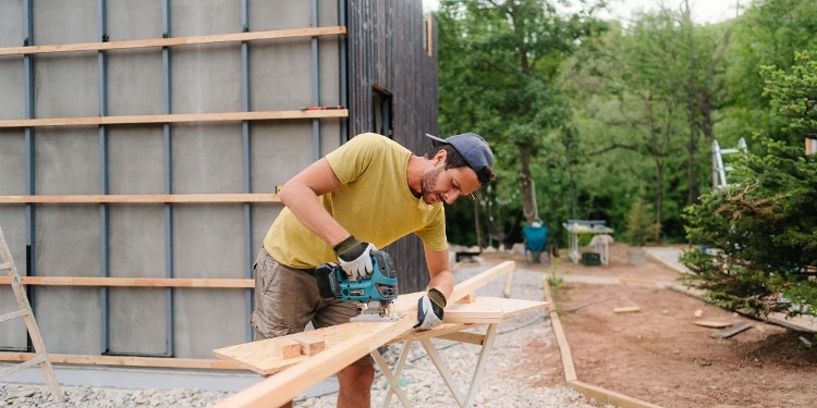 A person sawing through a piece of wood.