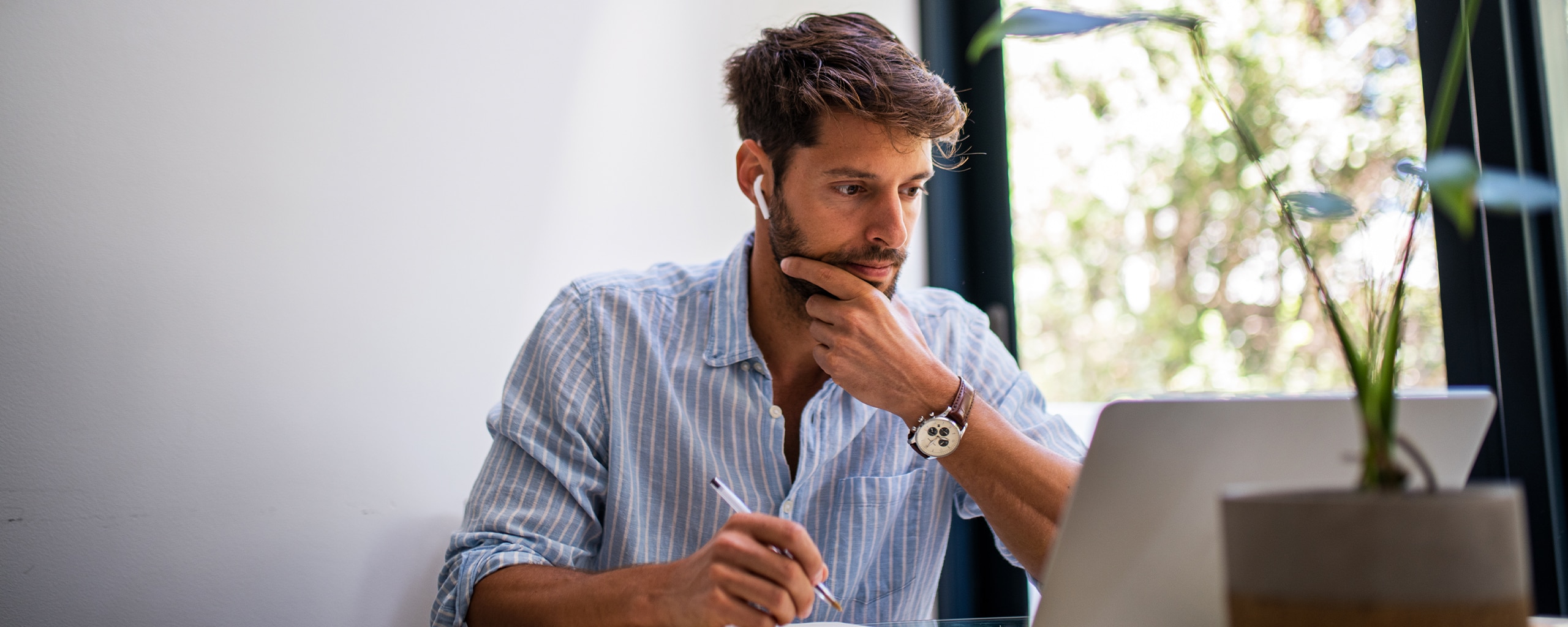 A person holding a pen looks at their Roth IRA withdrawal rules on a laptop.