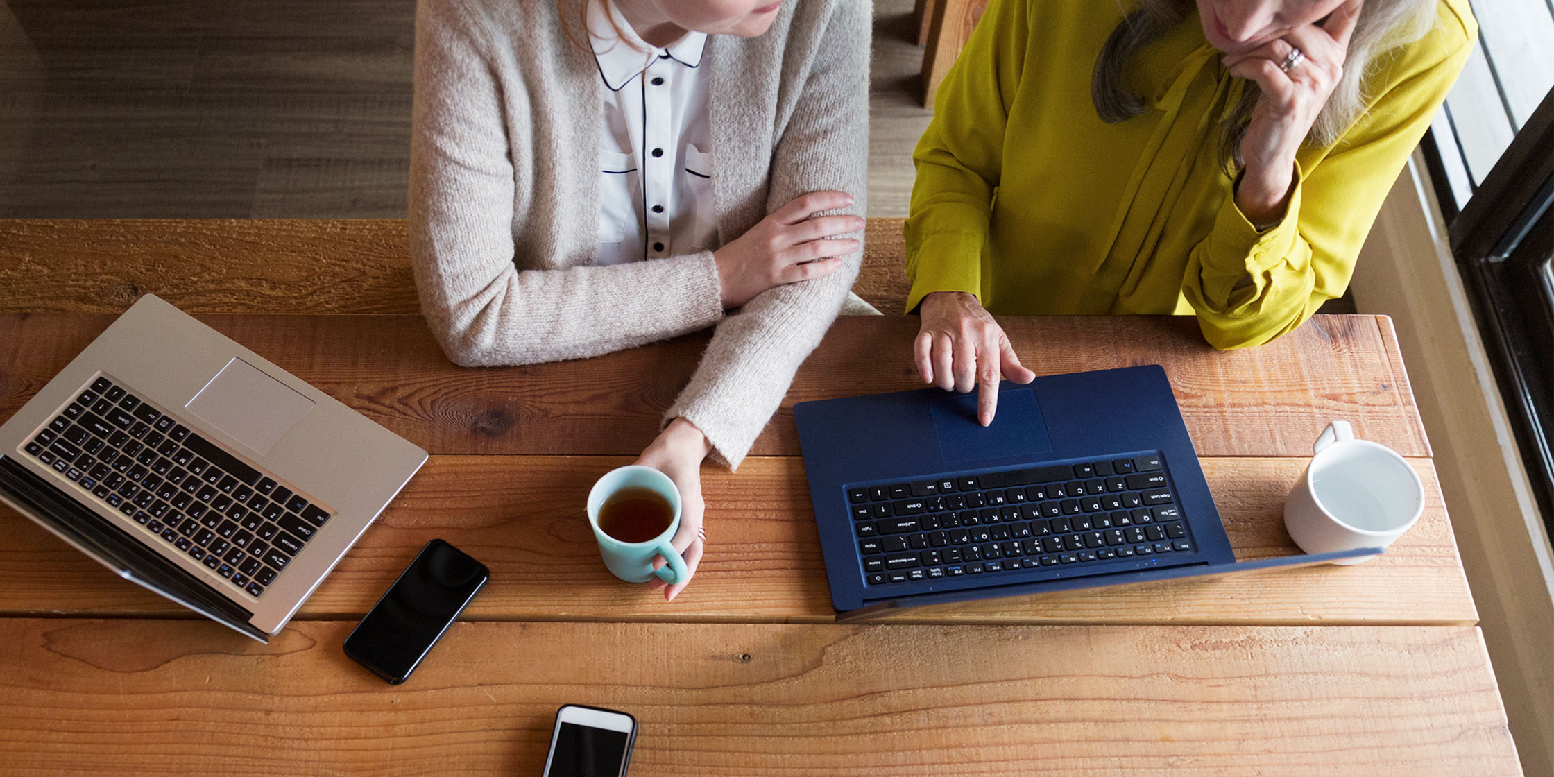 An overhead view of two people looking at credit score ranges on an open laptop.