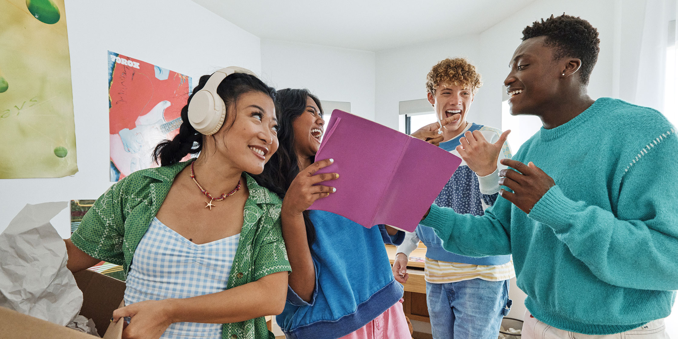 Students laugh together while moving into their dorm.