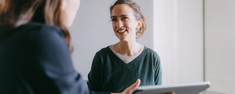A smiling person meeting with a financial adviser.