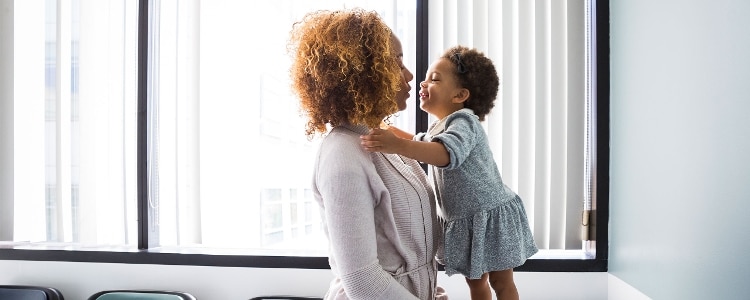 A parent holds their child while they wait in a doctor’s office