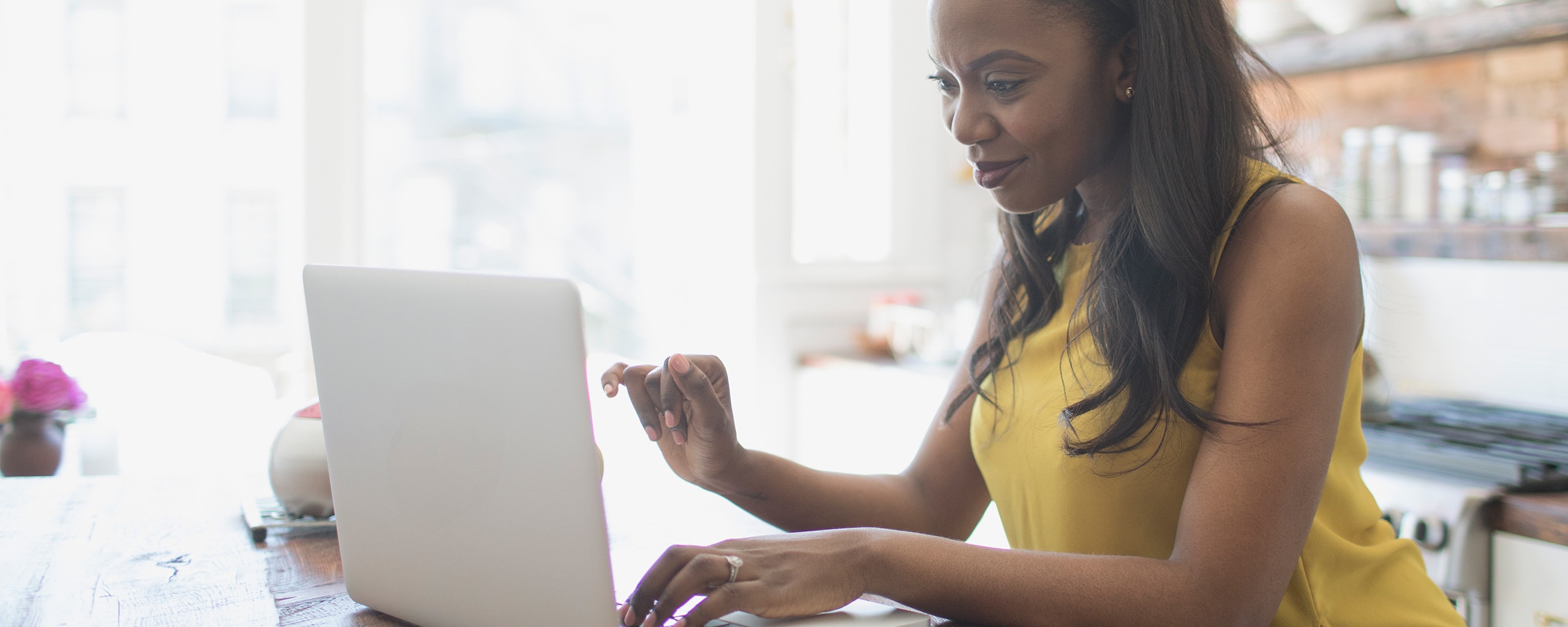 A woman uses Capital One Shopping on her laptop to find the best deal while shopping online.