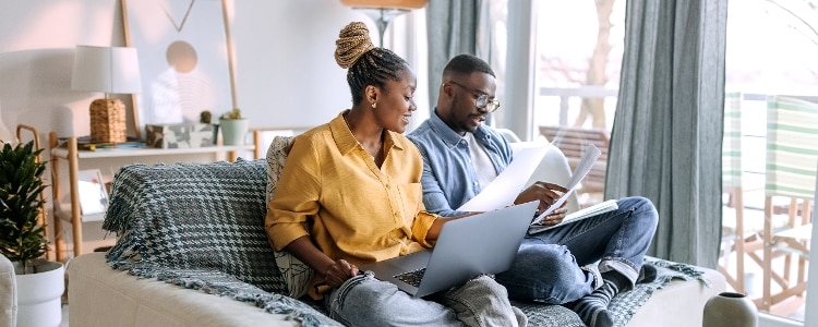 A couple prepares dinner together and checks their credit reports.