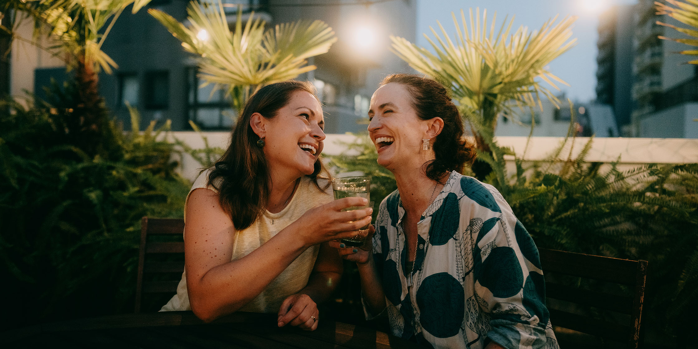 Two people laughing together at a restaurant.