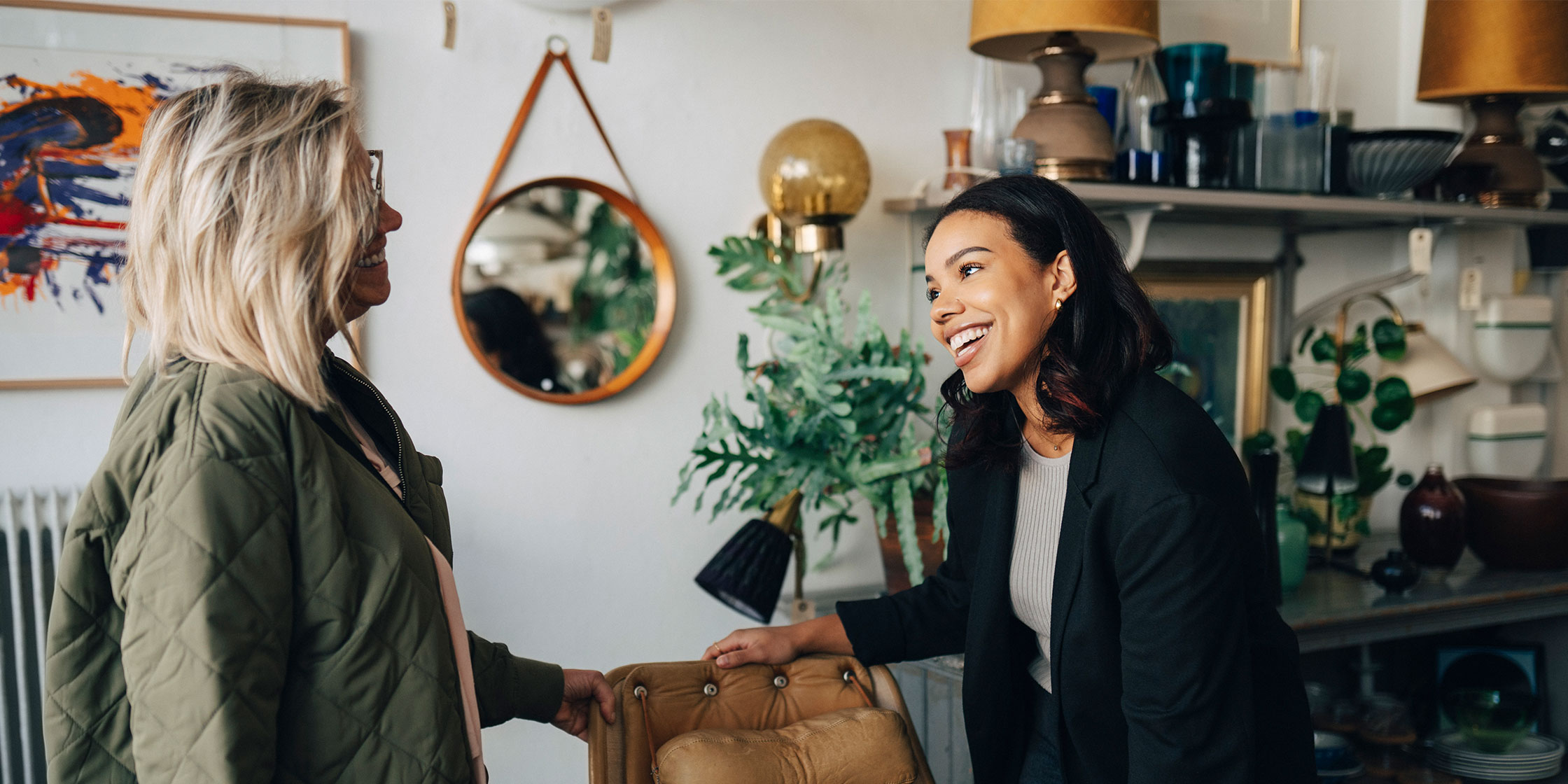 The owner of a home furnishings store smiles while talking with a customer.