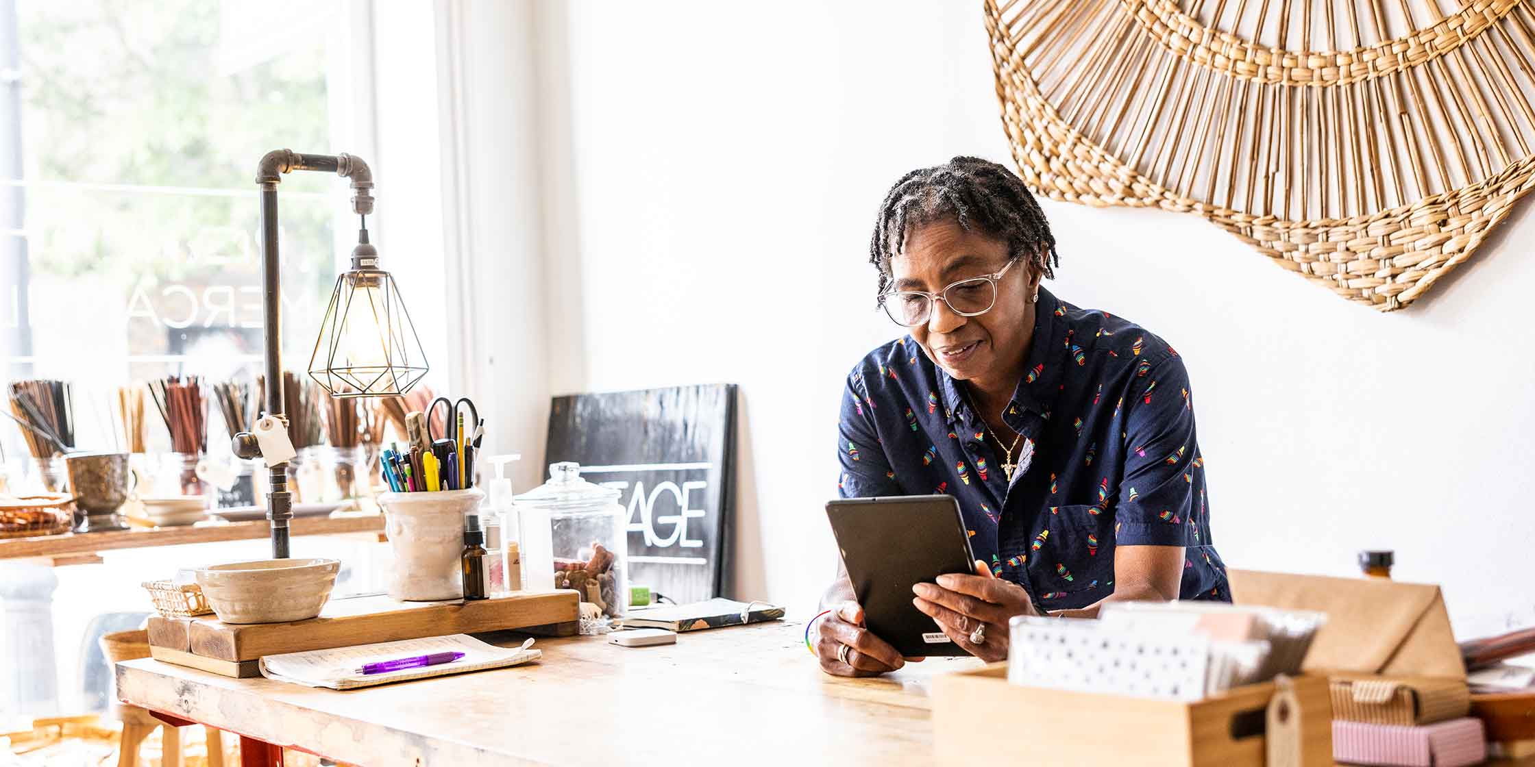 A person calculates their salary on a tablet while sitting at a desk.
