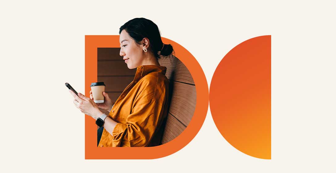 Person browsing on their phone while holding a coffee cup.