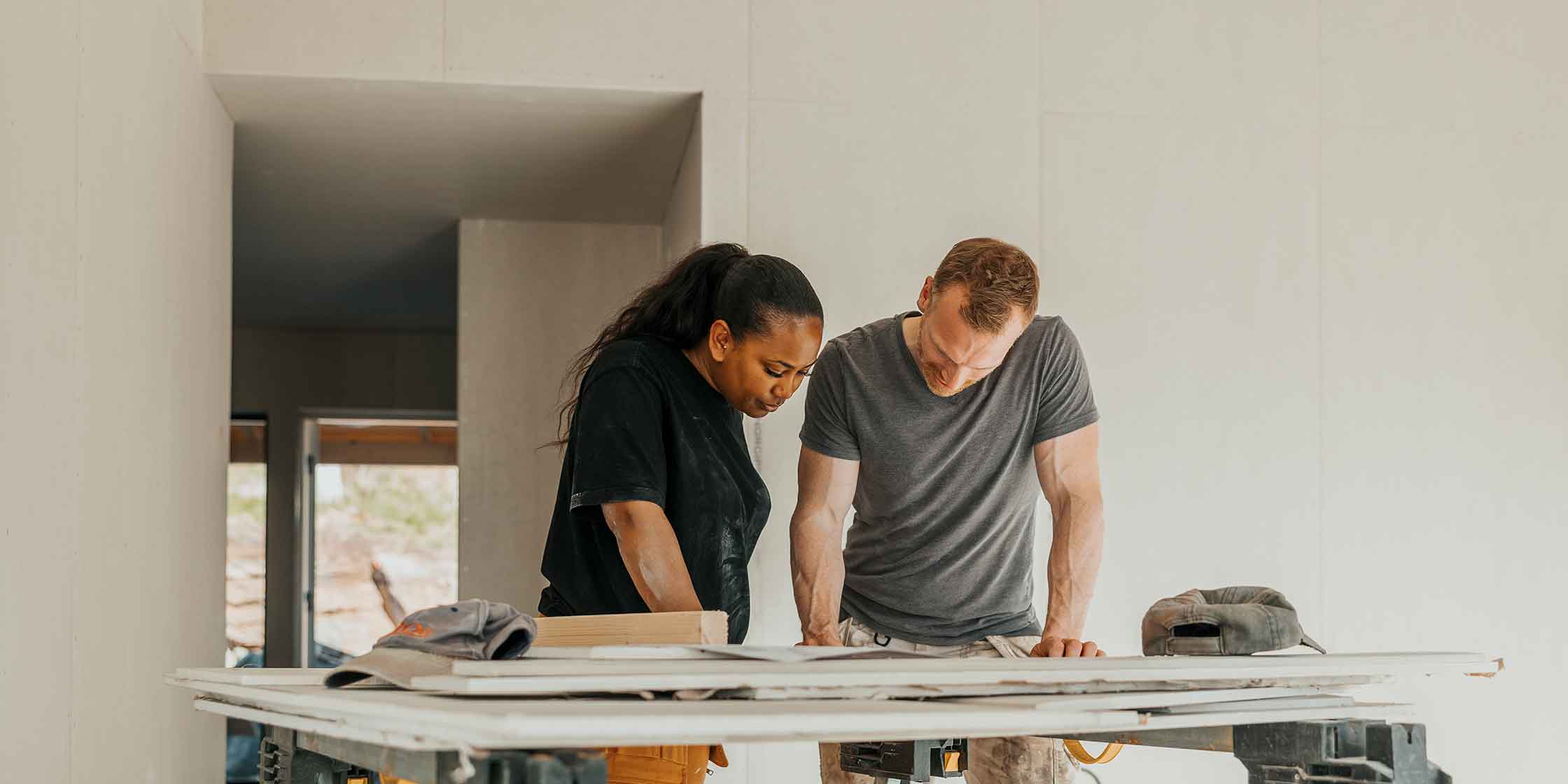 Two people discussing home improvement plans at a construction site.