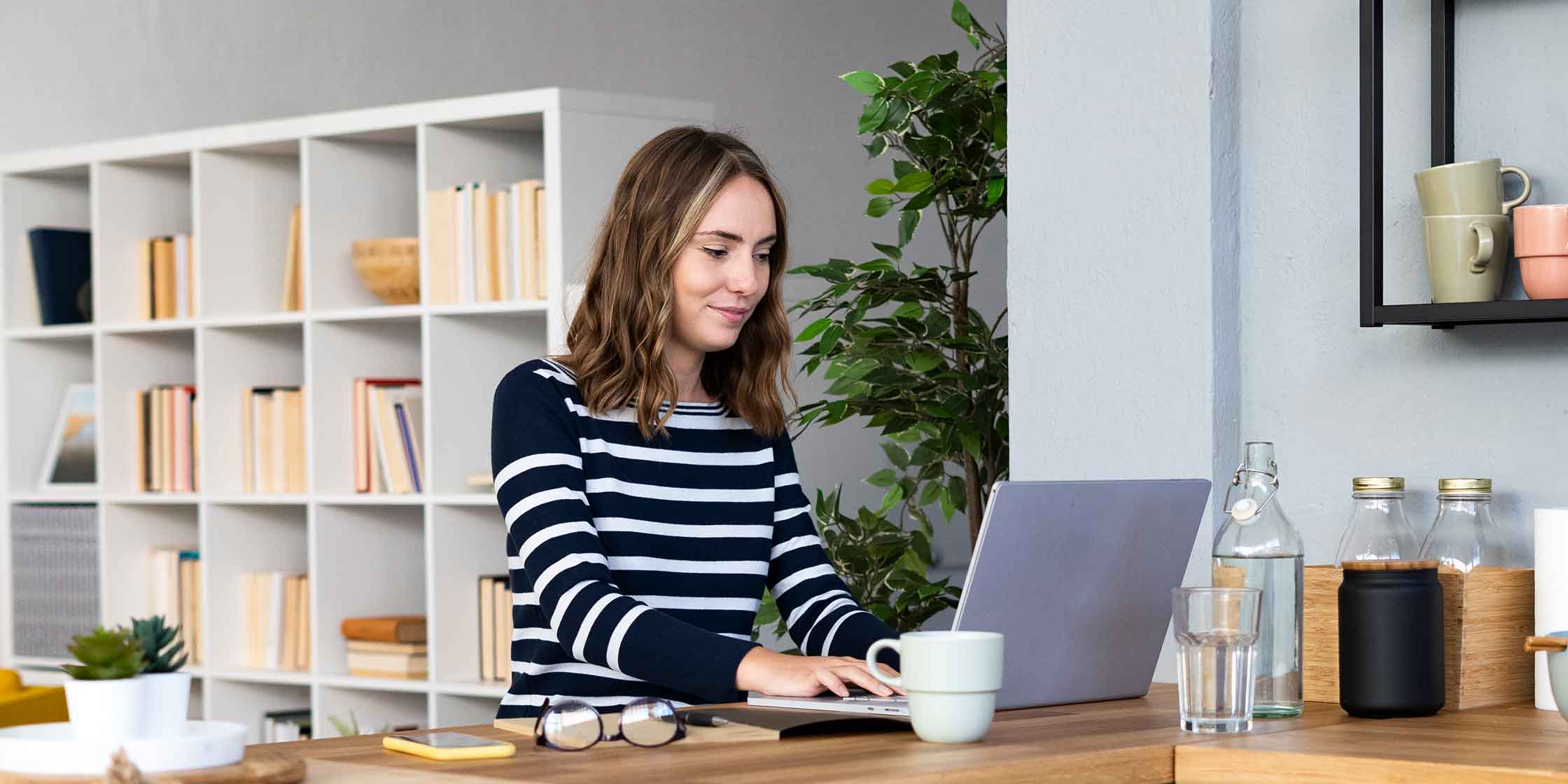 A person is sitting in front of their laptop and writing a cover letter for a job.