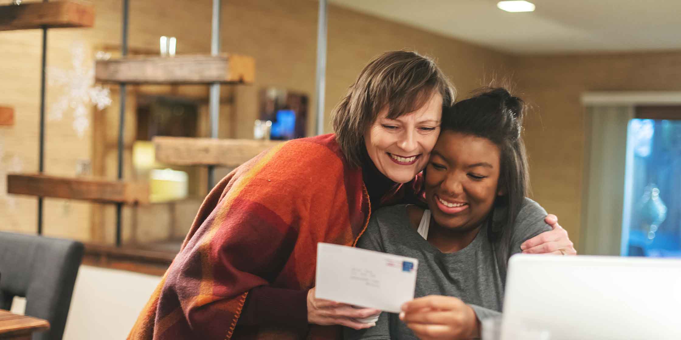 A photo of a smiling parent and child getting good news about a college scholarship offer.