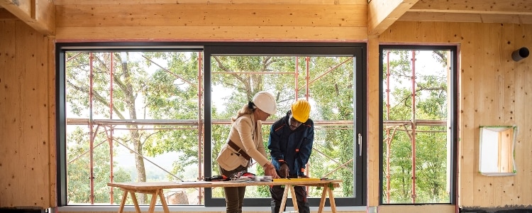 An architect and construction worker look at plans.