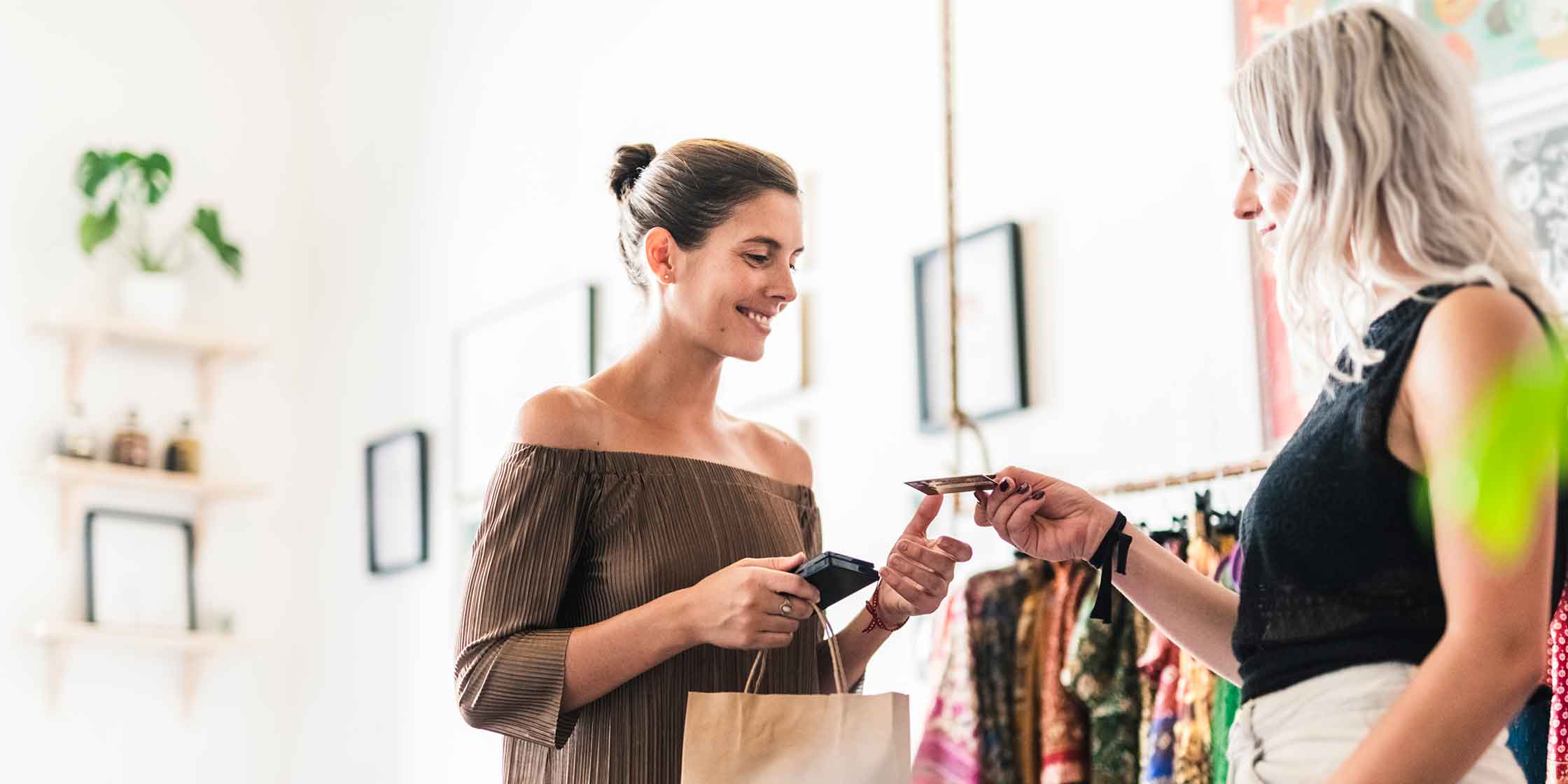 A person paying for a purchase at a clothing store with their credit card.