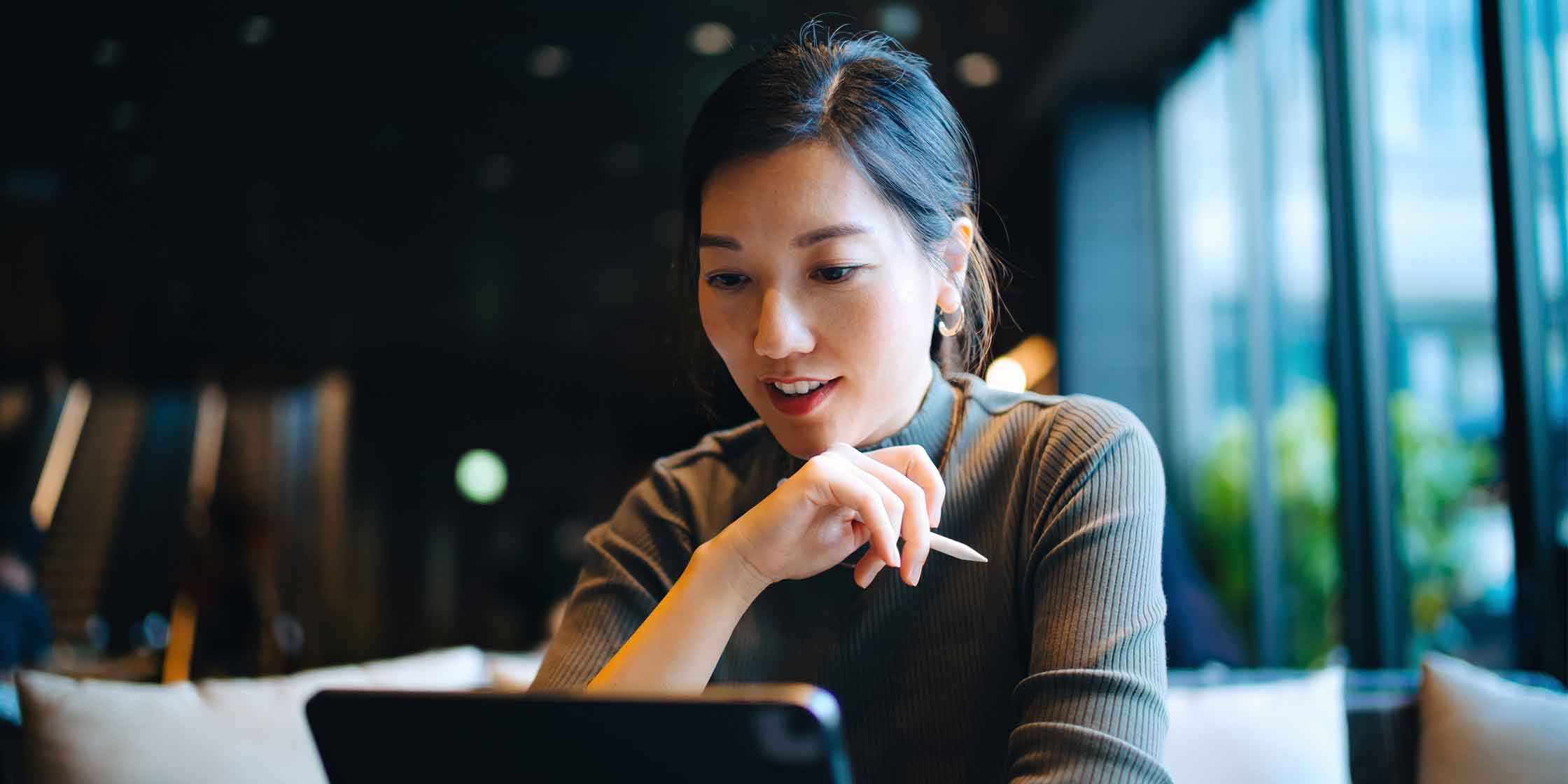 A person sitting at a table explores Capital One’s credit policies on a tablet.