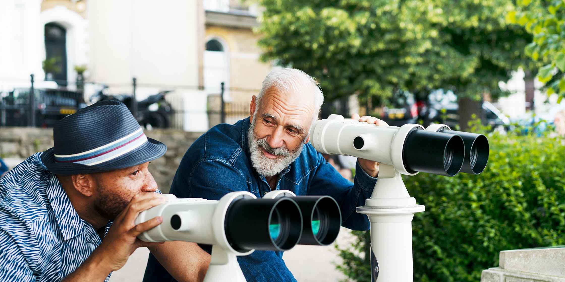 Two people using binoculars to look at a view.
