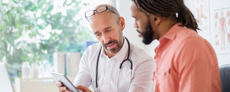 A photo of a patient discussing copays and deductibles with their doctor.