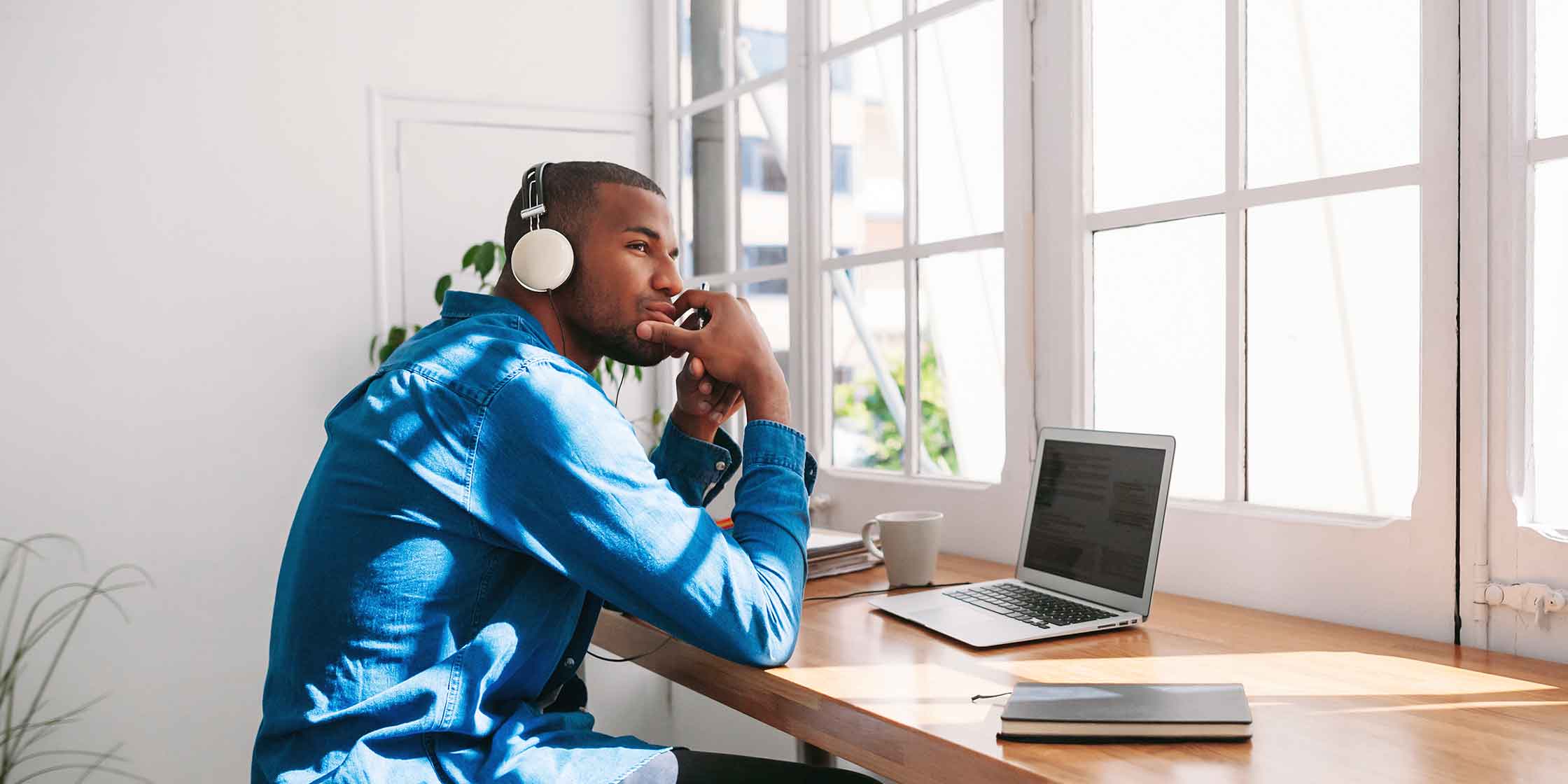 A person wearing headphones and working at a desk.